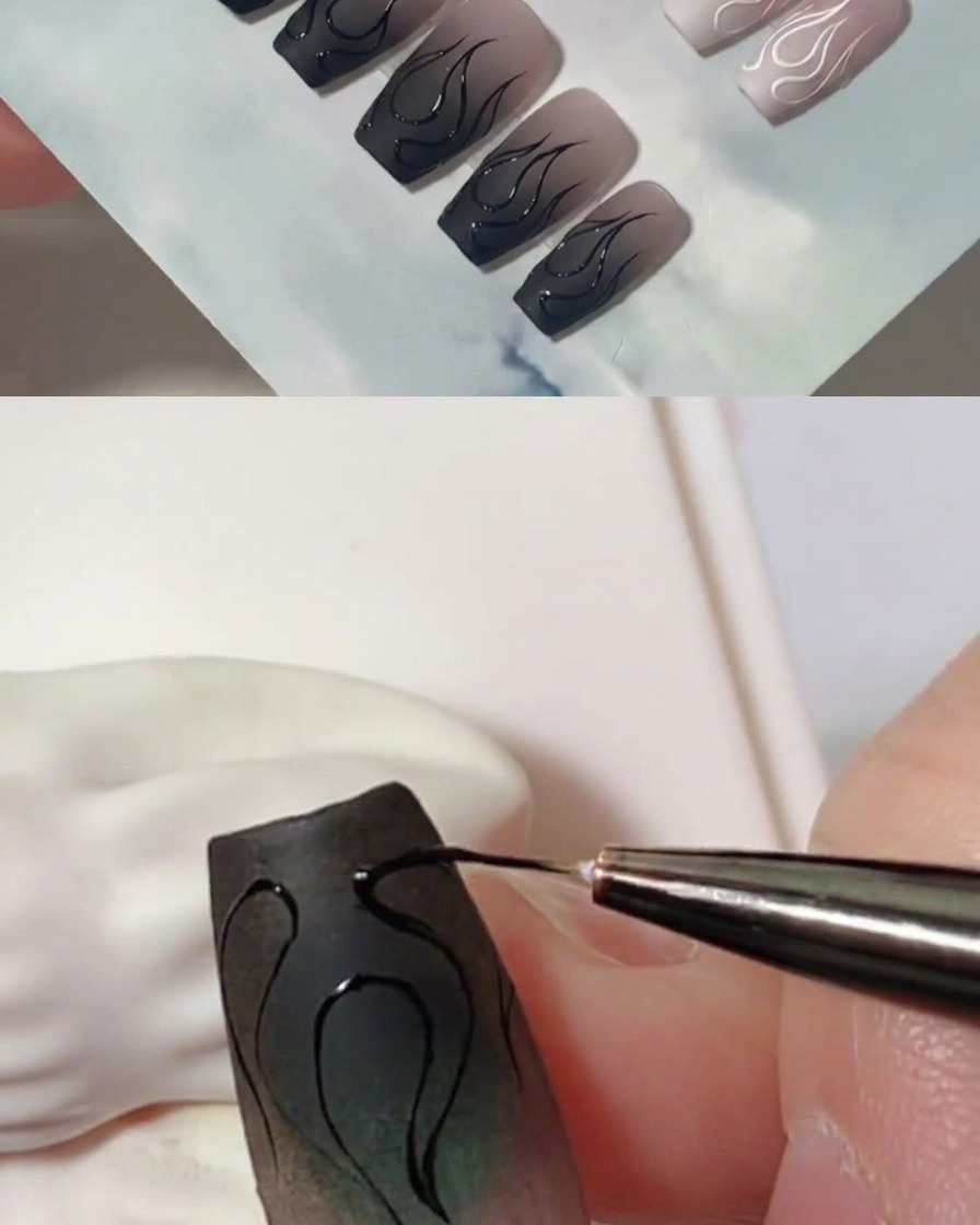 Primo piano che mostra un pennello liner che aggiunge strati di gel nero per ispessire i contorni della fiamma su ununghia opaca.