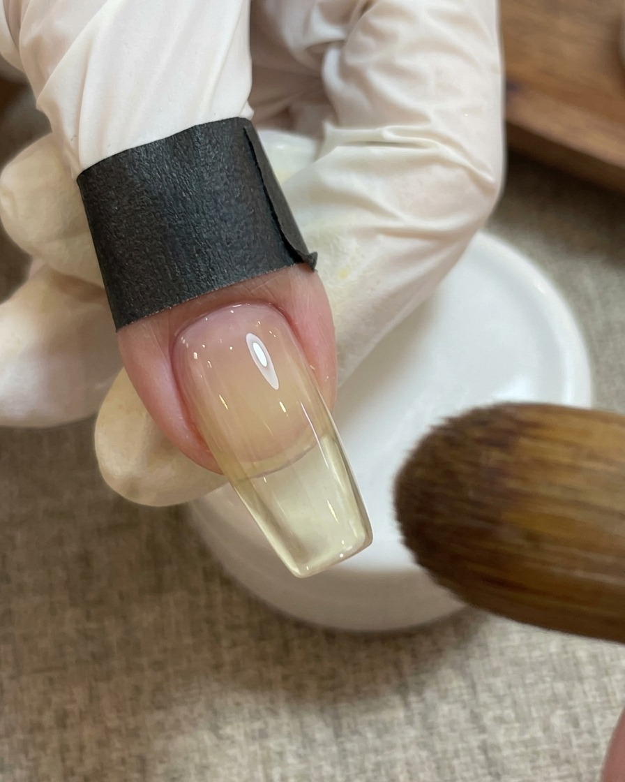 Un magnete tenuto sopra il design a cuore rosa sullunghia per creare un effetto scintillante.