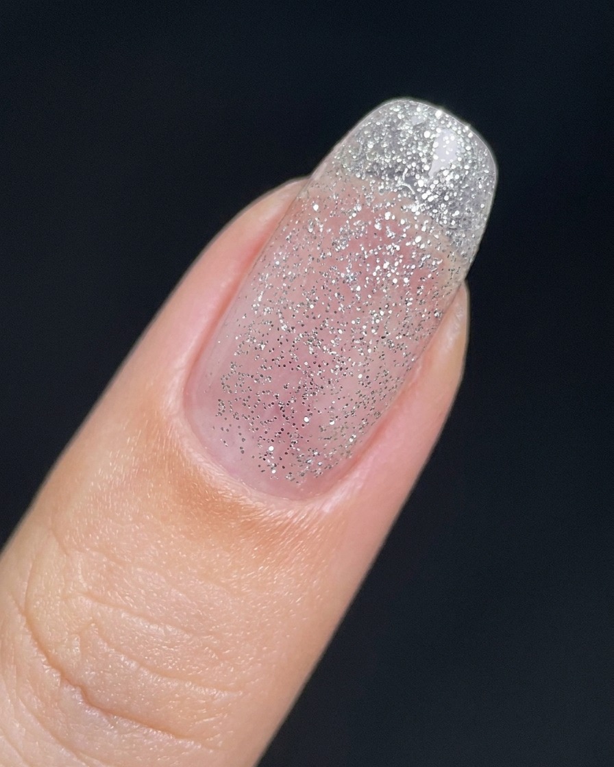 Ununghia coperta da un sottile strato trasparente di gel glitter argento fine.