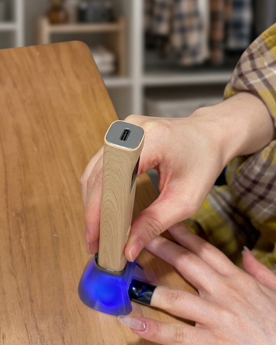 Un dito allinterno di una lampada UV mentre lo strato di top coat si polimerizza.