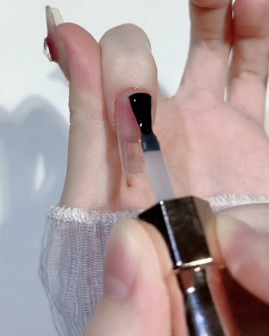 Una piccola goccia di gel rosa blush traslucido applicata al centro di una tip trasparente.