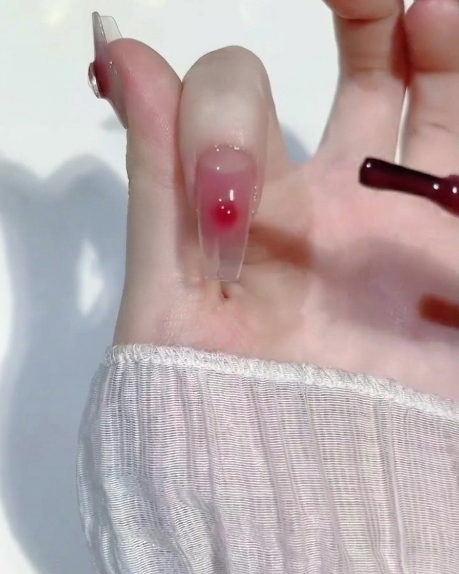 Una piccola goccia di gel rosa sfumata al centro dellunghia con un pennello di precisione.