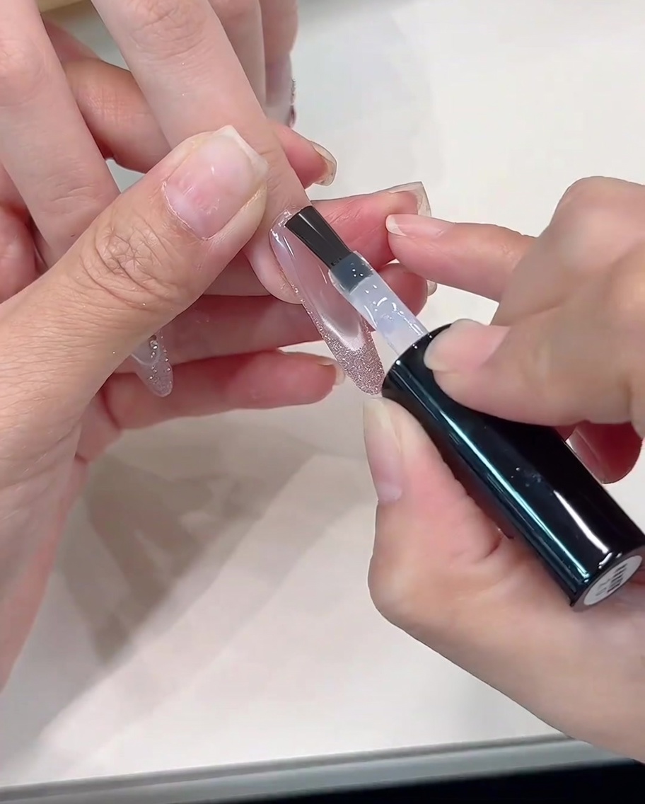 Un top coat trasparente viene applicato sul design French glitterato finito.