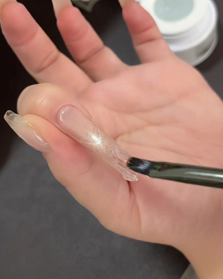 Primo piano di una guida adesiva per French tip posizionata sullunghia per definire larea della punta.