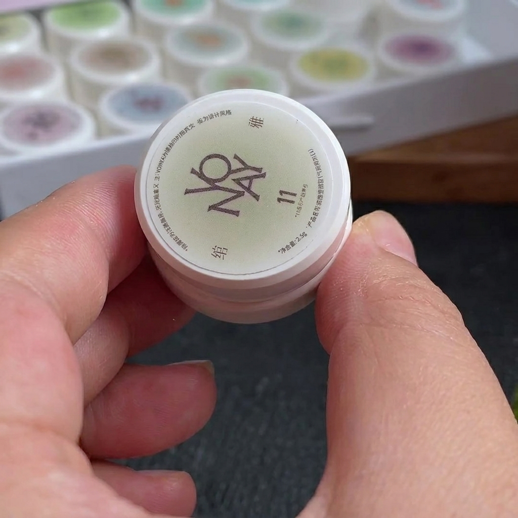 Una piccola spugna per trucco con linee di gel bianco e rosso rosato applicate sulla superficie.