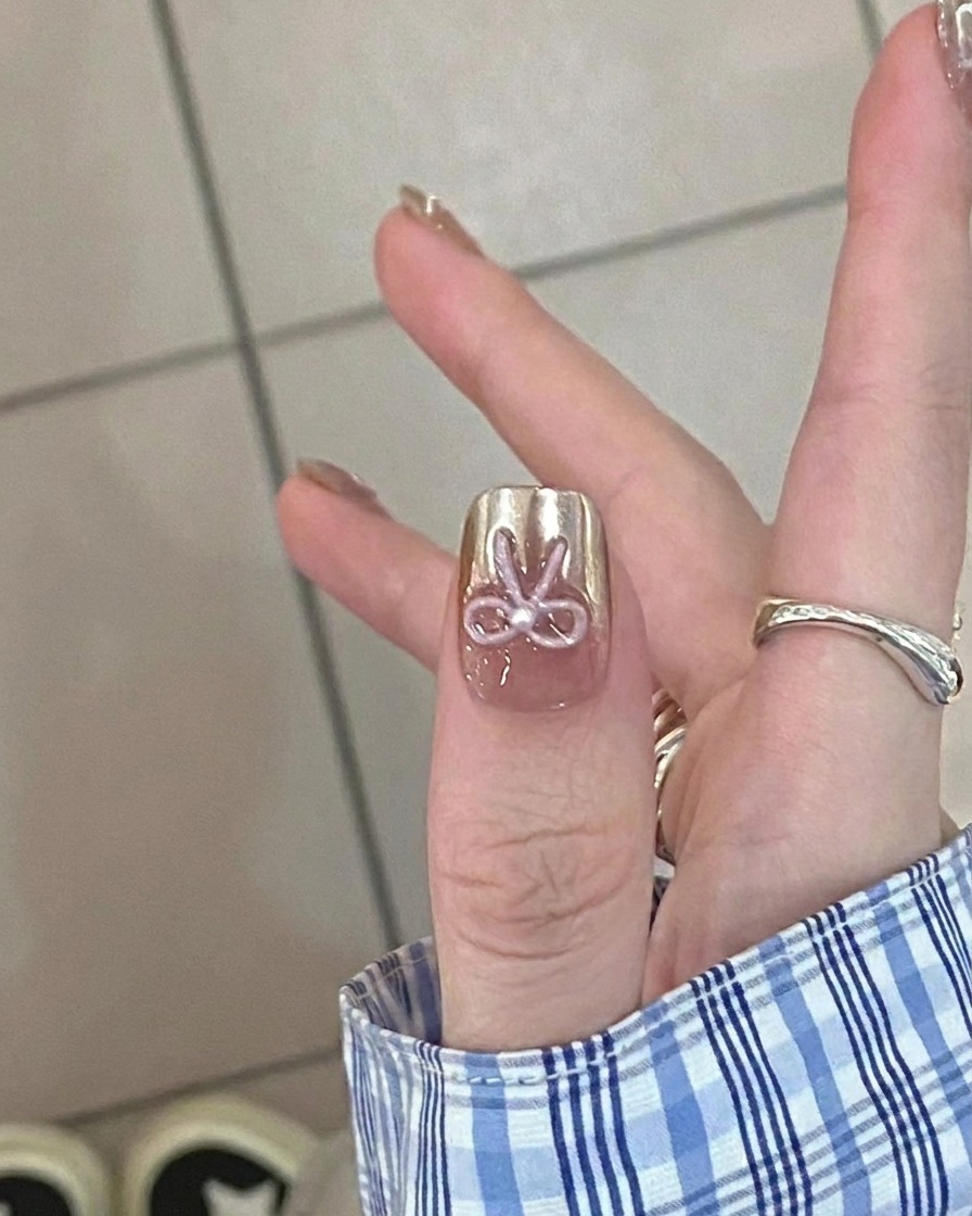 Primo piano di un pennello che applica uno strato sottile di base gel nude su ununghia naturale pulita.
