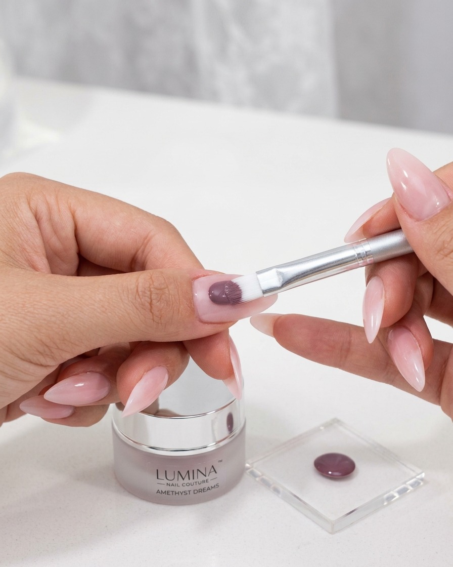 Un pennellino applica un gel cat-eye colorato e intenso sulla superficie dellunghia preparata.