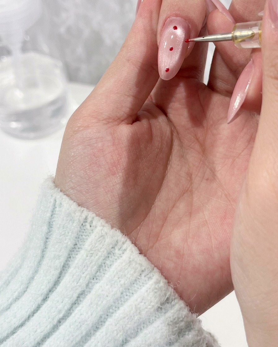 Primo piano di un pennello di precisione che applica una goccia di gel trasparente su ununghia.