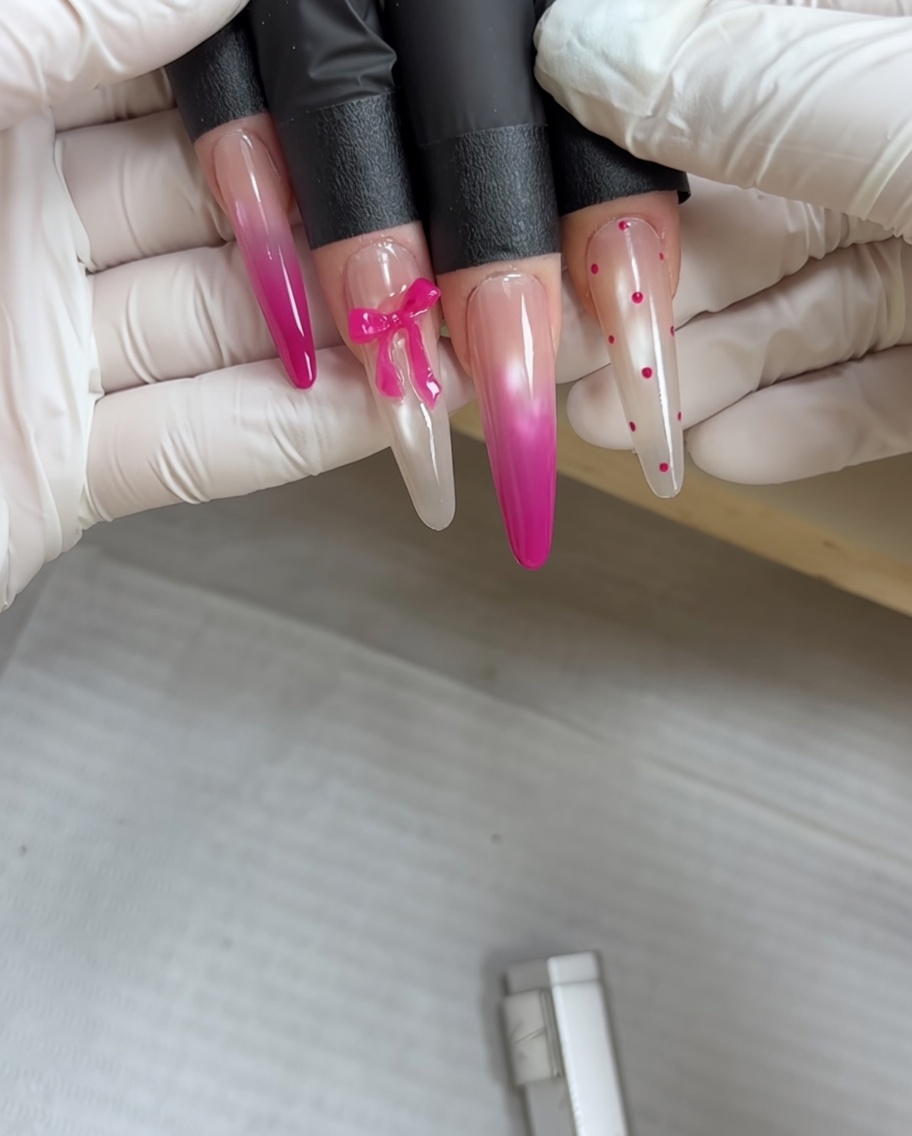 Uno strumento per puntinatura che applica minuscoli punti rosa su una superficie metallizzata grigia polimerizzata.