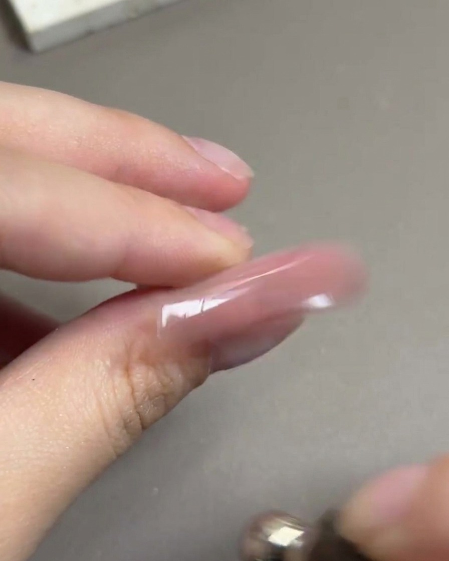 Uno strumento magnetico fatto ruotare con un movimento circolare attorno a ununghia per formare un riflesso sferico luminoso.
