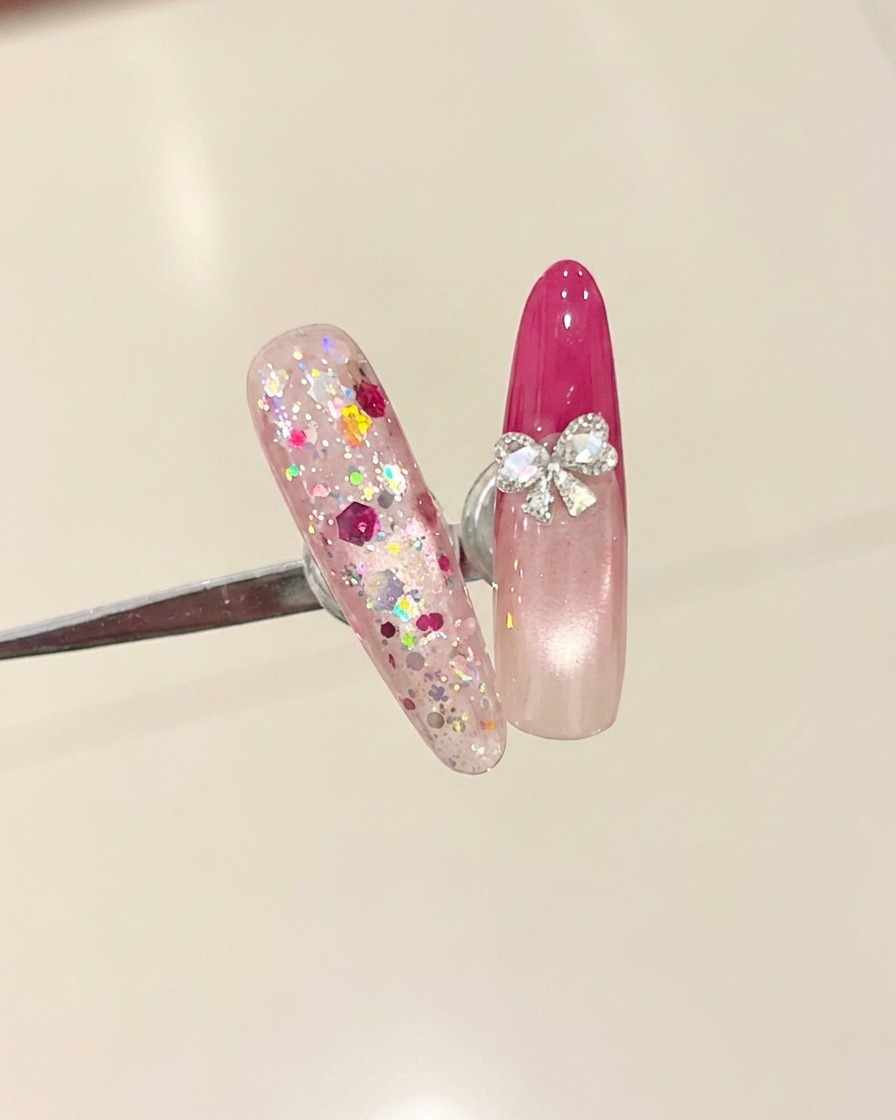 Un pennello che applica un top coat trasparente su ununghia con una french tip rosso rosa.