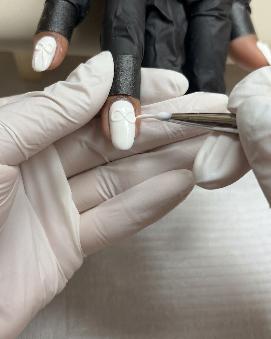 Un pennello sottile modella la seconda ala di un fiocco in gel 3D per farla combaciare con la prima.