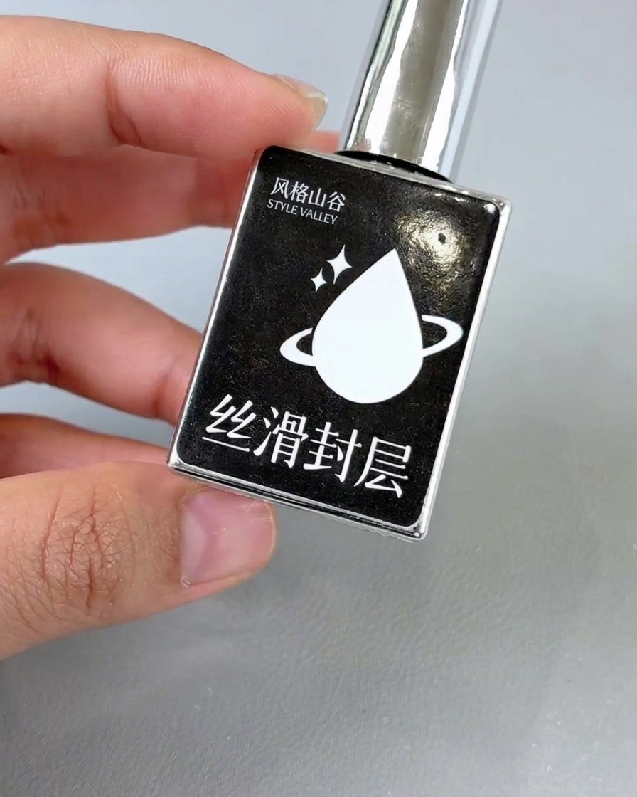 Un pennello che applica un top coat trasparente lucido su un design floreale finito.