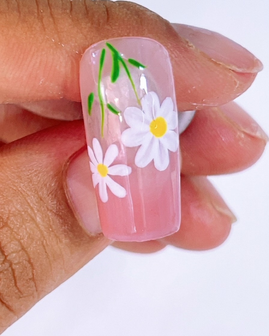 Gel bianco applicato con un pennello liner per formare i petali della margherita sopra le linee guida.