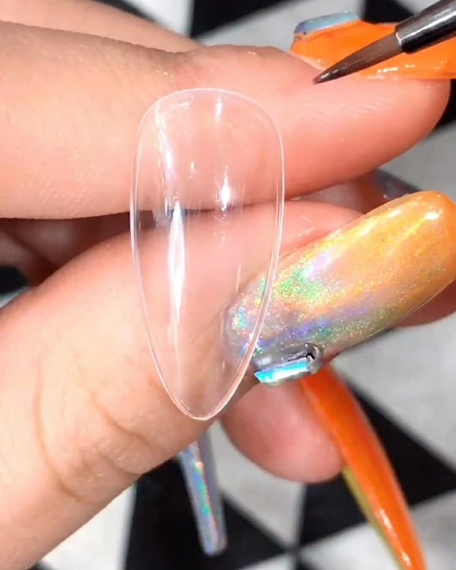 Primo piano di un pennello di precisione che applica gel bianco per formare la base dei petali di margherita su una tip.