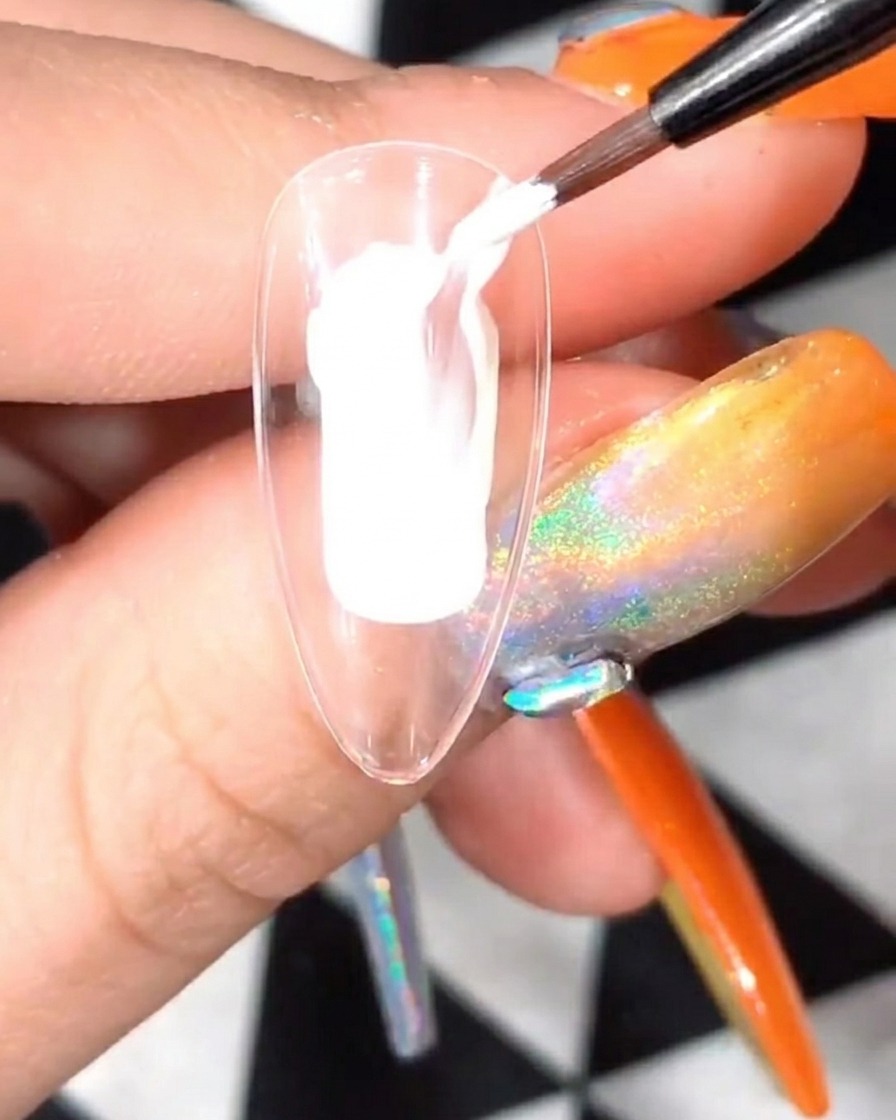 Una tip con petali bianchi inserita allinterno di una lampada UV/LED per unghie.