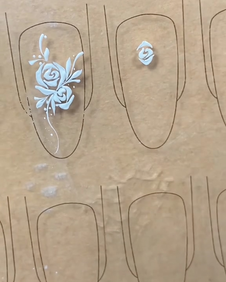 Un pennello liner che disegna una linea a forma di arco sopra il bocciolo centrale stabilito.