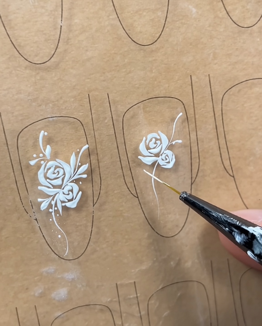 Un design per unghie con una rosa e un viticcio, con linee strutturali iniziali tracciate per segnare dove saranno posizionate le foglie.