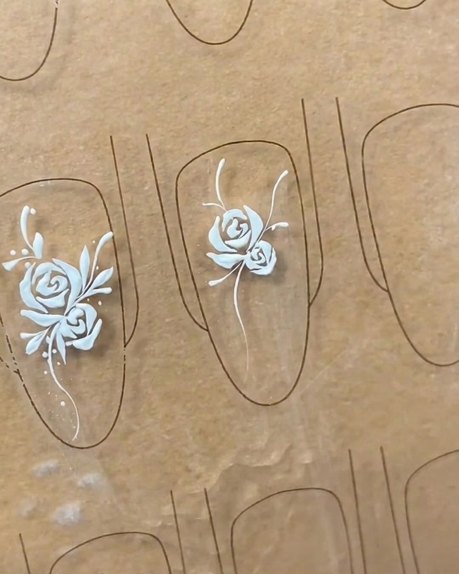 Primo piano che mostra la rifinitura delle forme delle foglie su una nail art, aggiungendo dettagli e pienezza.