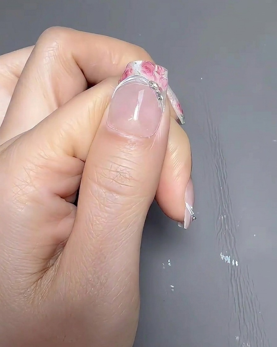 Una mano allinterno di una lampada professionale UV/LED con la luce accesa, mentre le unghie sono in fase di polimerizzazione.
