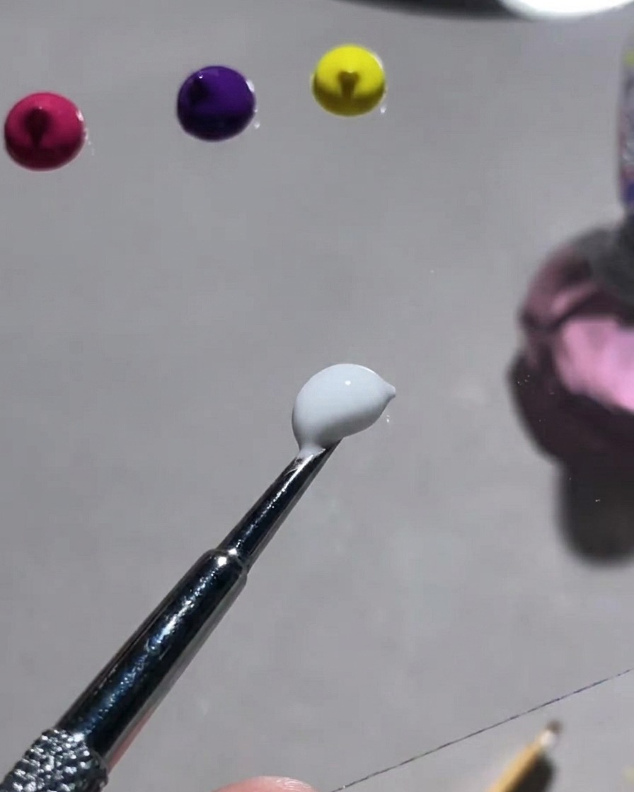 Una tavolozza che mostra varie polveri colorate vibranti e uno strumento utilizzato per mescolarle con il gel gypsum bianco.