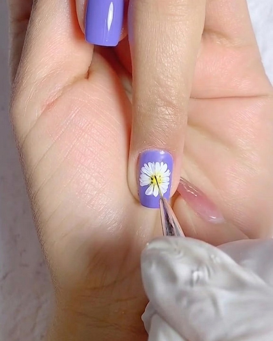 Un pennello che applica uno strato uniforme di smalto gel bianco su ununghia del pollice.
