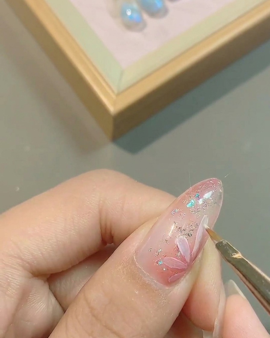 Primo piano di un pennello che traccia con precisione i bordi dei petali bianchi.