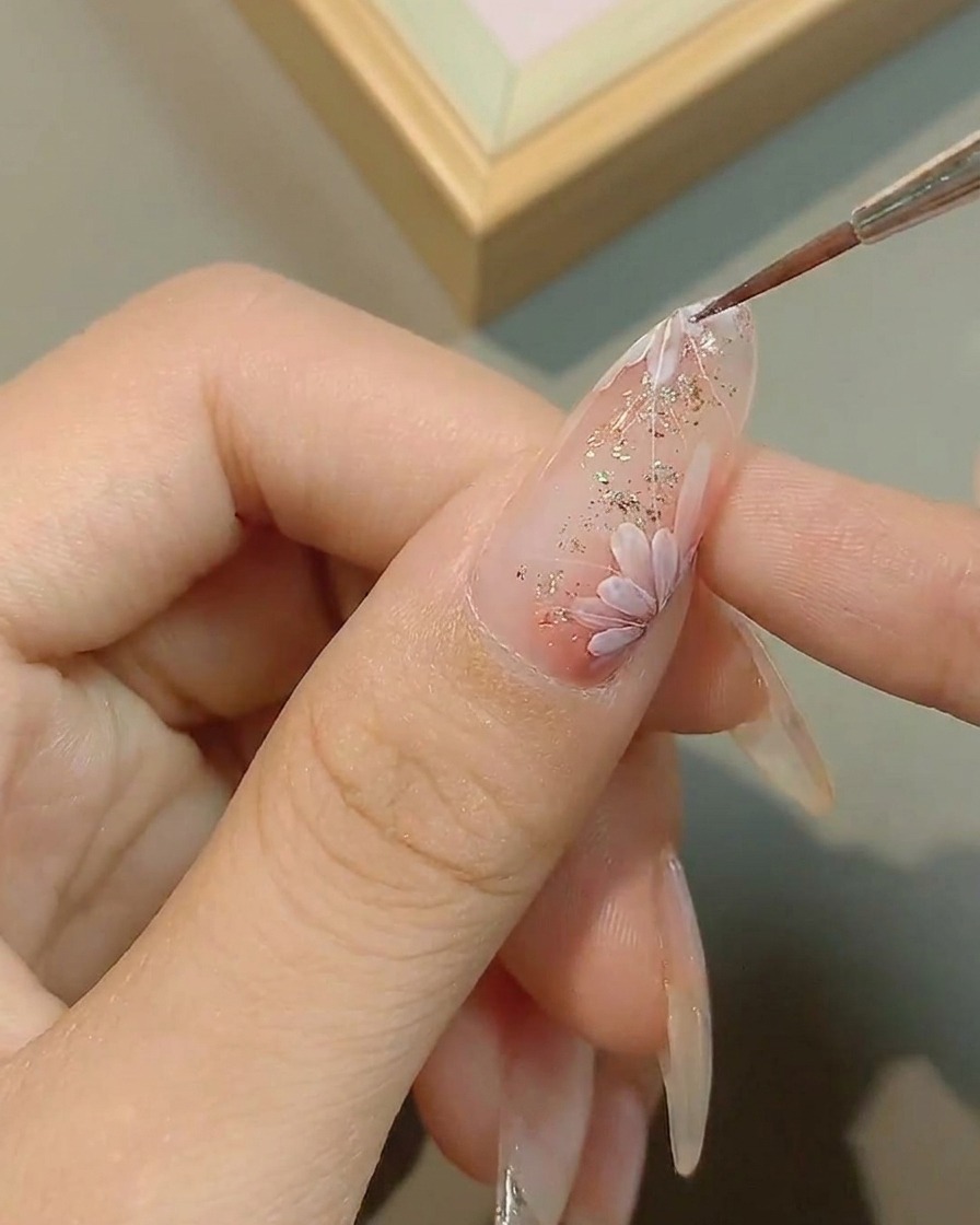Un pennello sottile aggiunge dettagli precisi al centro di una margherita dipinta.