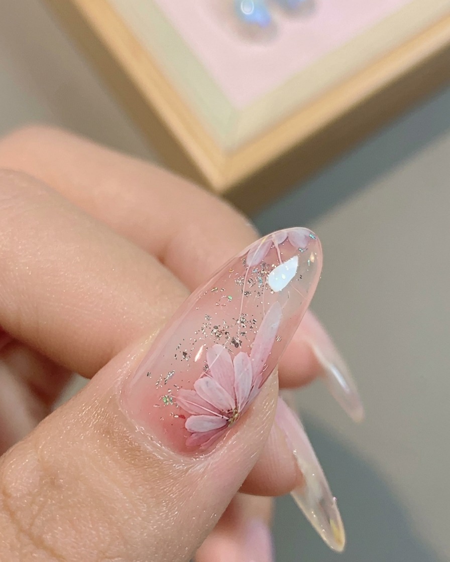 Un pennello applica un top coat lucido finale sopra il design a margherita completato.
