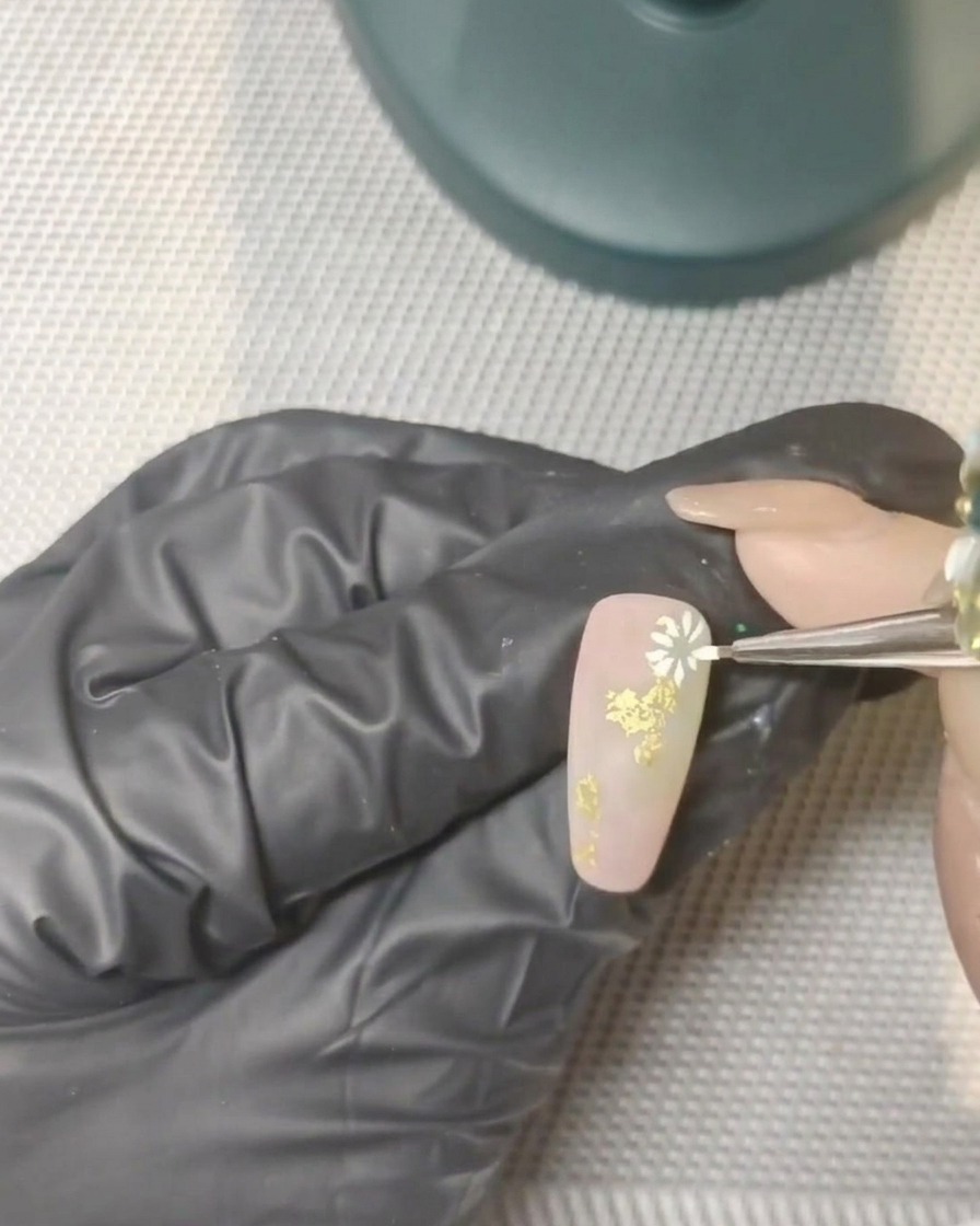 Una mano con le unghie decorate inserita in una lampada UV professionale.