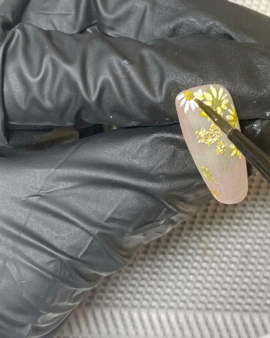 Una vista ravvicinata del design finale con margherite mentre polimerizza allinterno di una lampada.