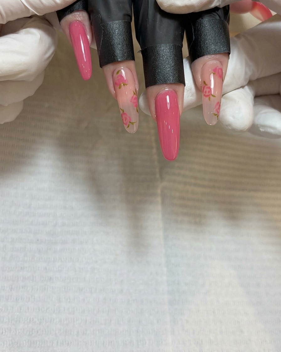 Primo piano del pennello di precisione che dipinge un terzo grappolo di petali di rosa vicino alla punta dellunghia.