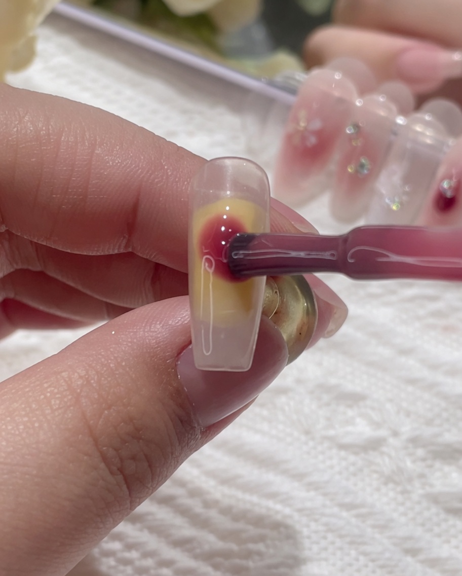 Gel rosa che viene applicato a gocce sulla superficie bagnata dellunghia.