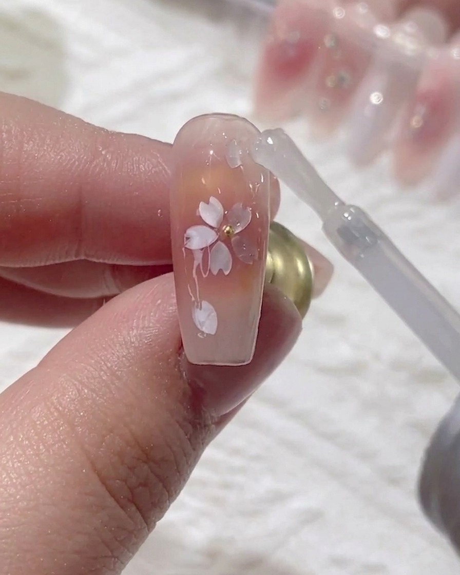 Un pennello applica un top coat finale ultra-lucido sopra il design incapsulato.