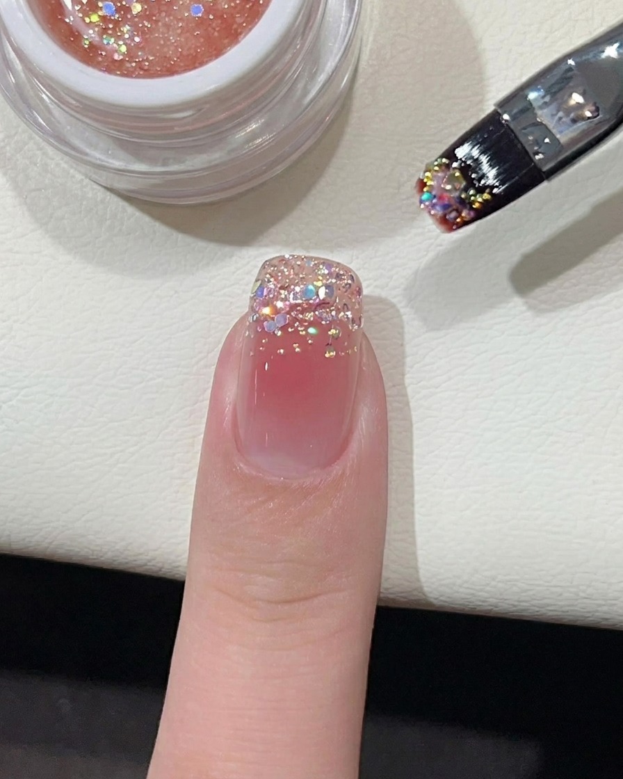 Un piccolo punto di smalto gel rosa vibrante posizionato al centro di ununghia rivestita di base nude.