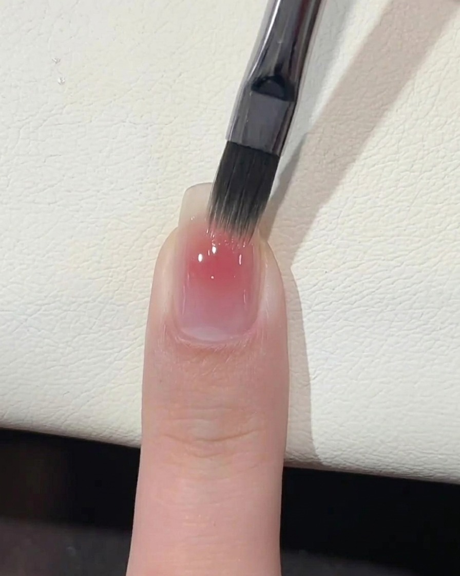 Una mano posizionata sotto una lampada professionale per unghie UV per la polimerizzazione.