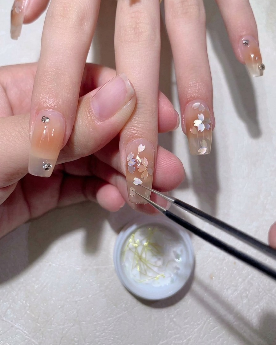 Un pennello da gel che applica uno strato liscio di top coat su un design per unghie finito.