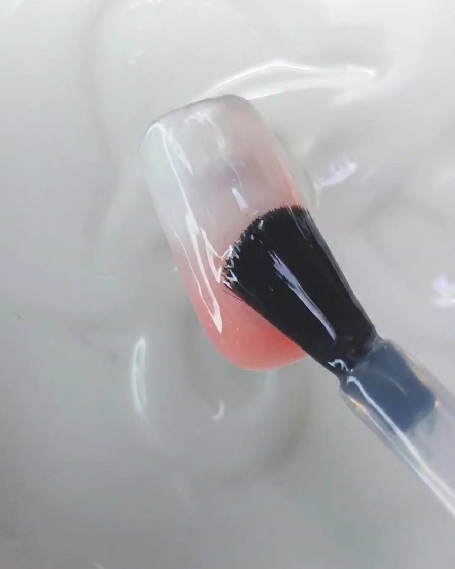 Uno strumento in silicone che strofina la polvere cromo aurora sulla superficie di ununghia.