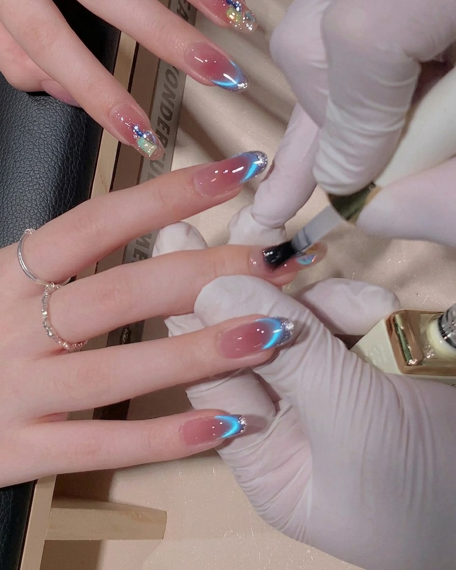Un pennello che applica uno strato di top coat gel lucido su ununghia decorata, rendendo la superficie brillante e dallaspetto bagnato.