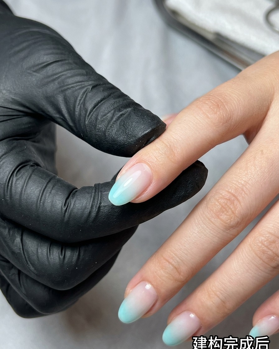 Una spugnetta per trucco che picchietta smalto gel blu e beige su ununghia per creare un effetto ombré.