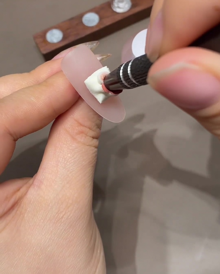 Ununghia con effetto ombré che viene polimerizzata allinterno di una lampada per unghie UV professionale.