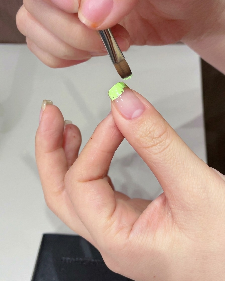 Una spugnetta usata per picchiettare e ammorbidire il gel verde sulla punta dellunghia.