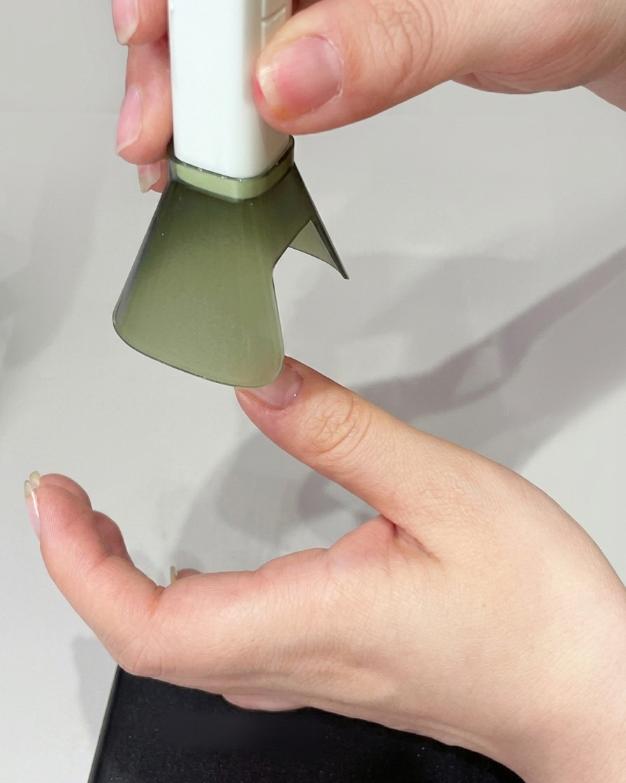 Una mano posizionata sotto una lampada UV per polimerizzare lunghia.