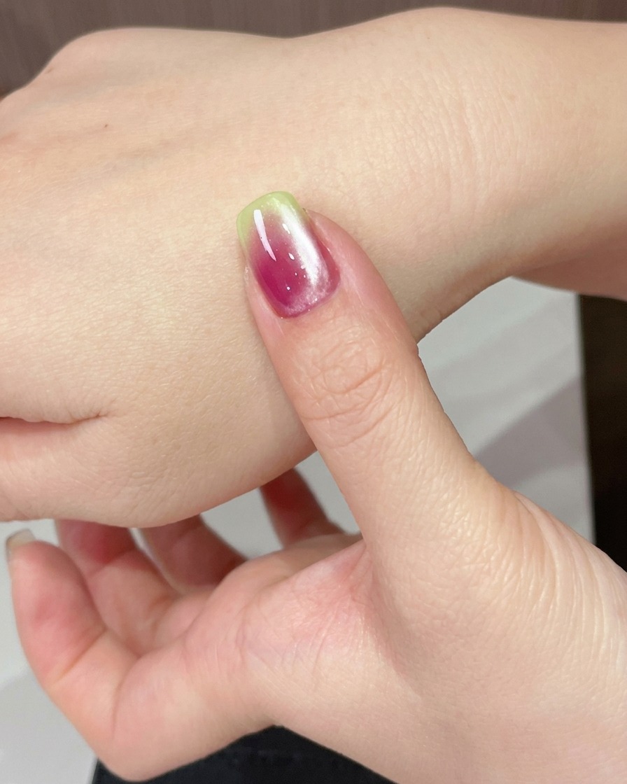 Una mano posizionata sotto una lampada UV per polimerizzare il gel cat eye appena applicato.