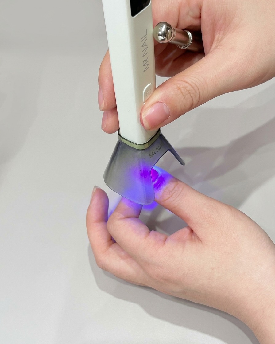 Una piccola spugnetta per makeup che applica smalto gel verde sulla punta dellunghia per scurire il colore.