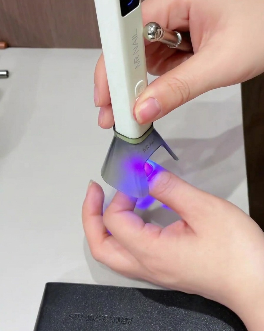 Un pennello che applica un top coat lucido su tutta la superficie dellunghia.