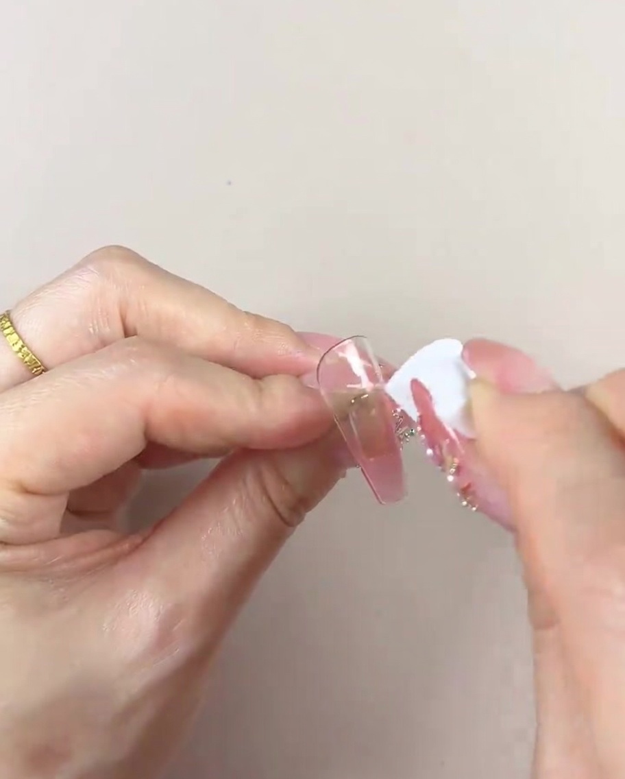 Una mano usa una parte pulita di una spugnetta cosmetica per levigare il gradiente di colore.