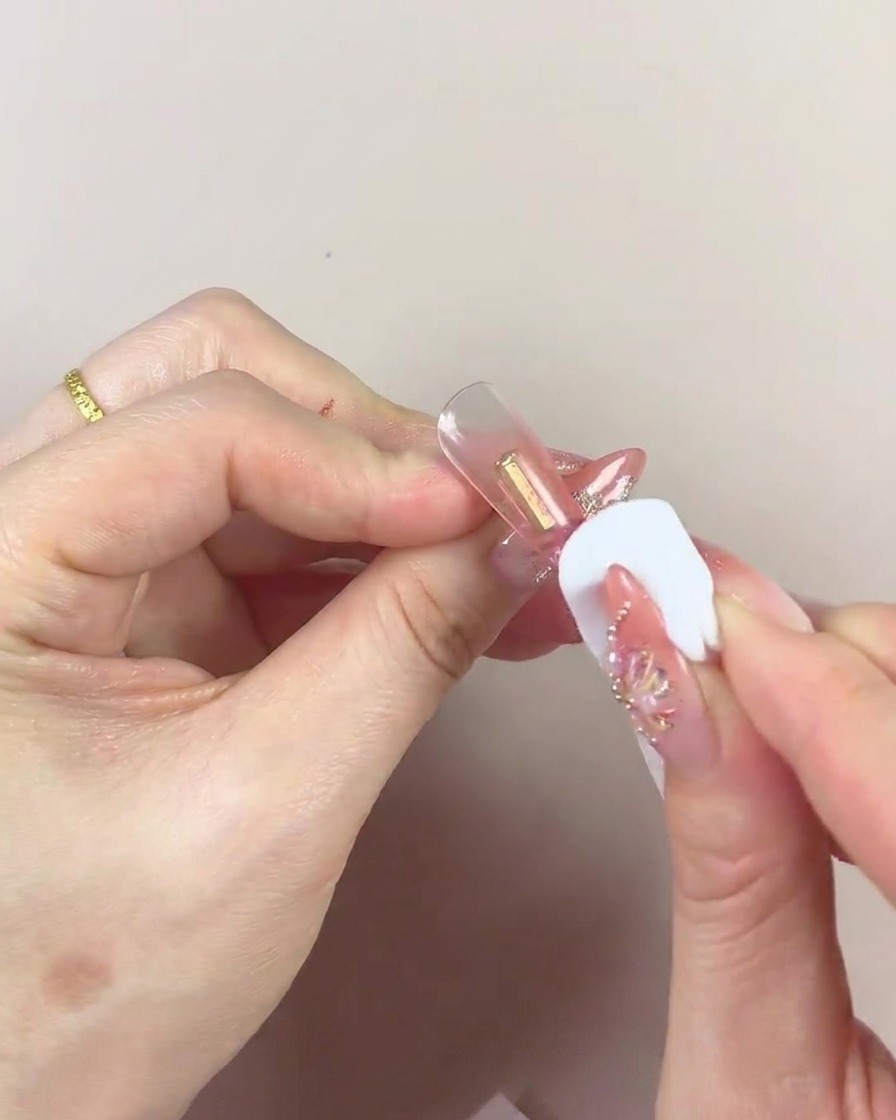 Primo piano di una spugnetta cosmetica con centro scuro che picchietta gel sulla punta.