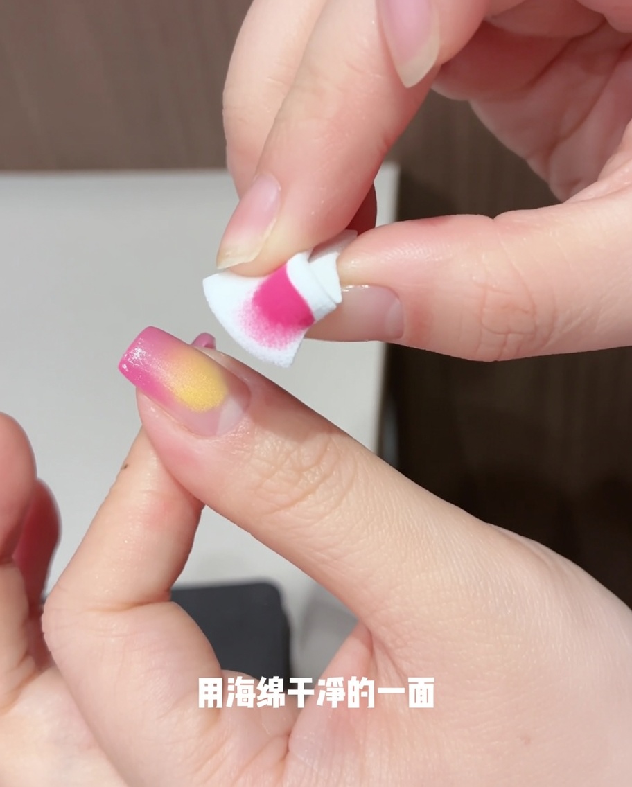 Una spugnetta utilizzata per picchiettare e diffondere delicatamente il gel giallo sullunghia, creando una forma sfumata simile a un petalo.
