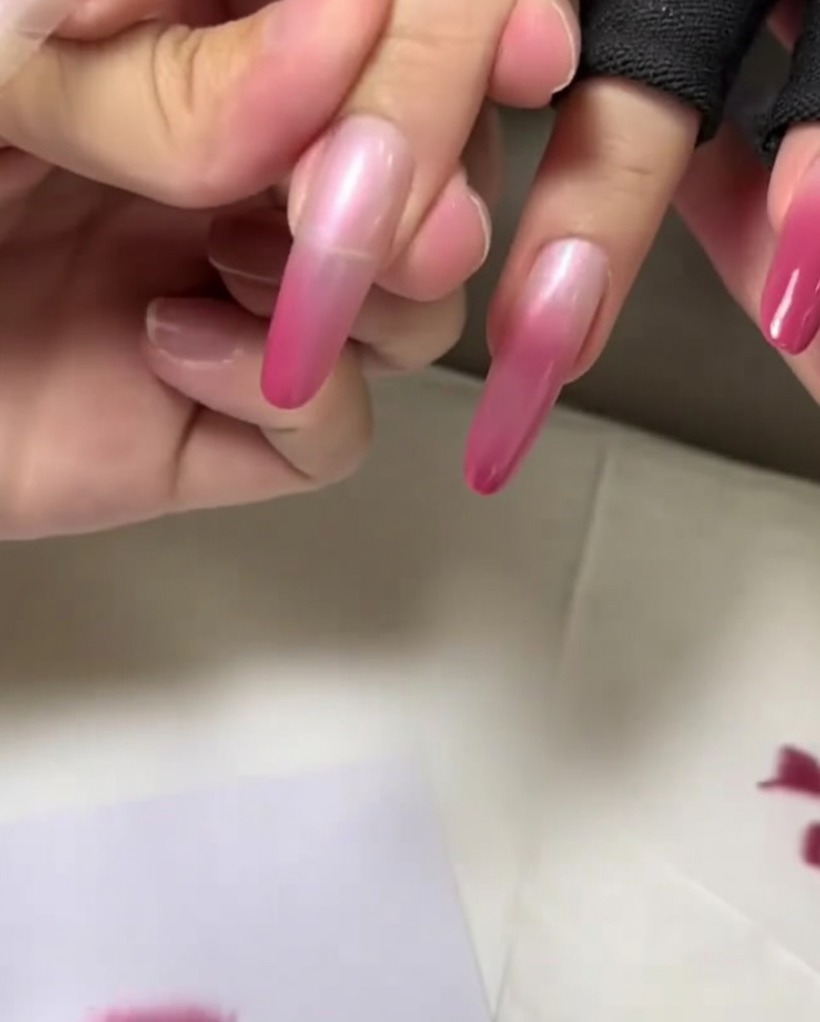 Un primo piano della punta dellunghia picchiettata con il colore rosa più scuro per finalizzare il gradiente.